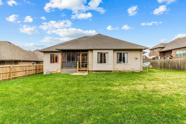 rear view of house featuring a yard and a sunroom