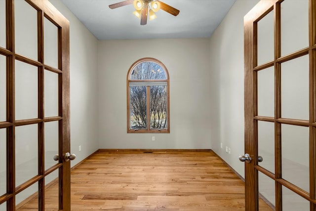 unfurnished room featuring french doors, ceiling fan, and light wood-type flooring