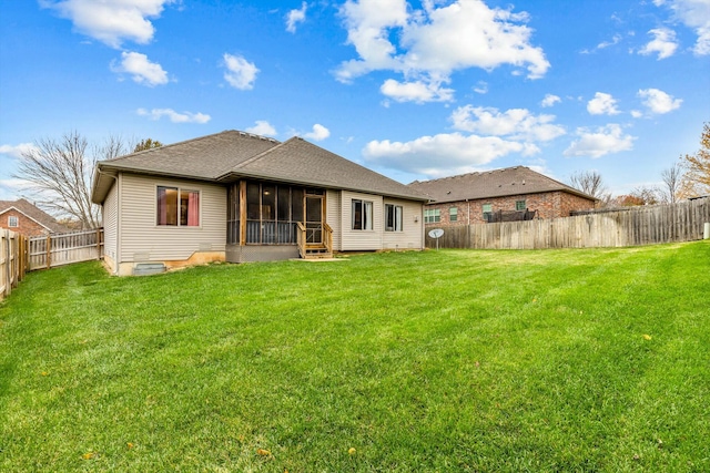 rear view of house with a sunroom and a lawn