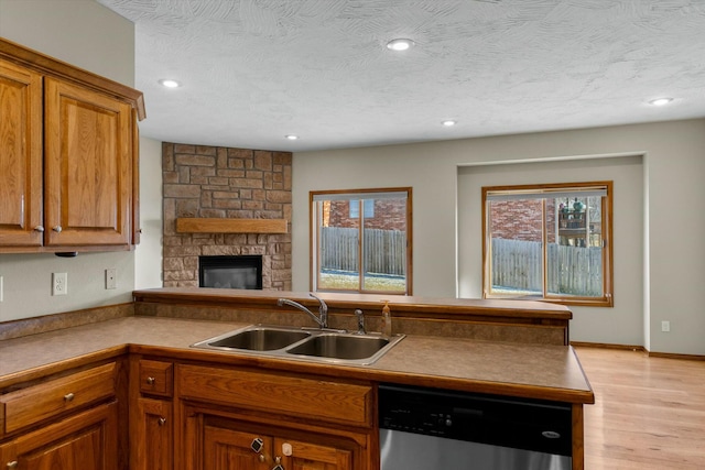 kitchen with dishwasher, sink, a textured ceiling, and a wealth of natural light