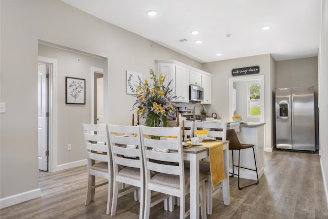 dining room featuring dark wood-type flooring, recessed lighting, and baseboards