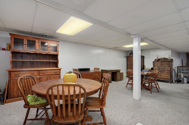 carpeted dining area featuring a paneled ceiling