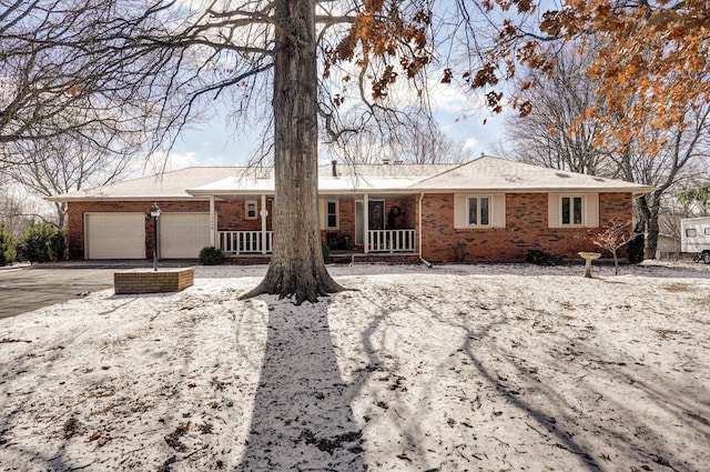 ranch-style house featuring a garage and covered porch