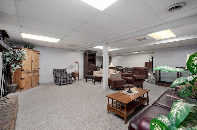 carpeted living room featuring a drop ceiling