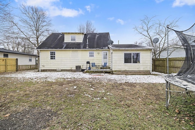 back of house featuring a trampoline and central air condition unit