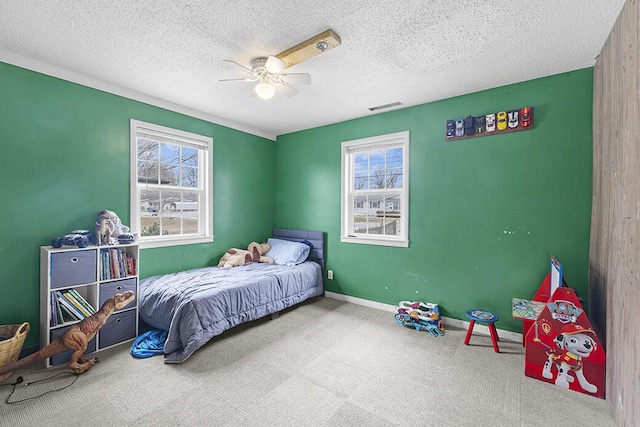 bedroom with ceiling fan, carpet floors, and a textured ceiling