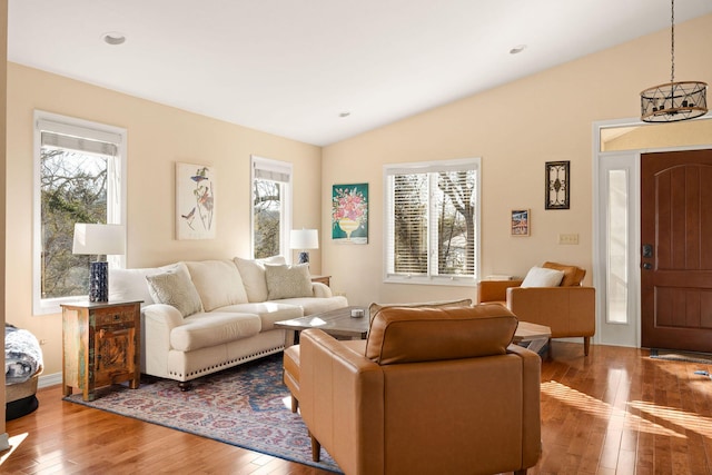 living area featuring vaulted ceiling, recessed lighting, an inviting chandelier, and light wood-style floors