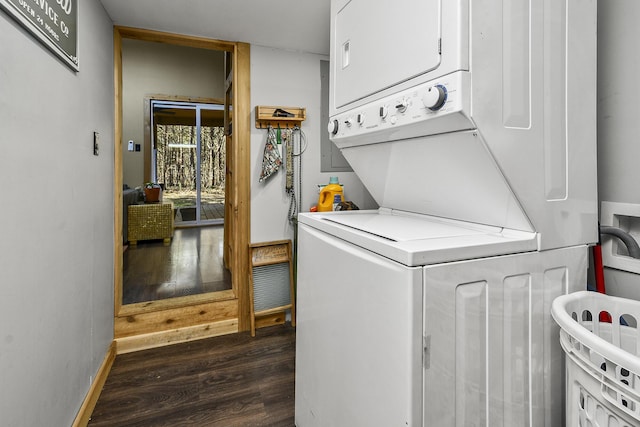 laundry room featuring dark hardwood / wood-style floors and stacked washing maching and dryer