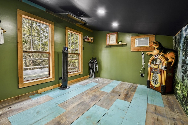 interior space featuring hardwood / wood-style floors and an AC wall unit