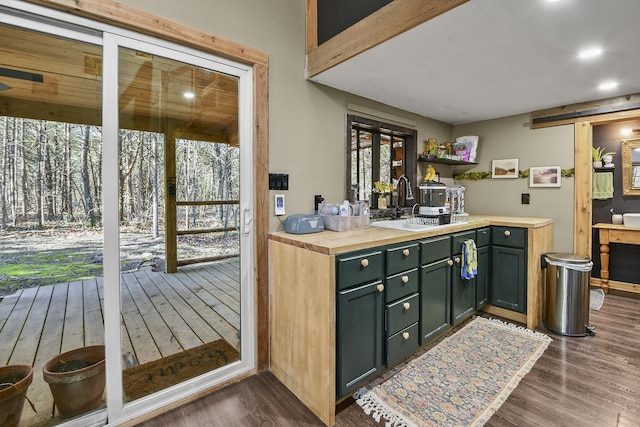 kitchen featuring sink, green cabinets, dark hardwood / wood-style floors, wood counters, and a barn door