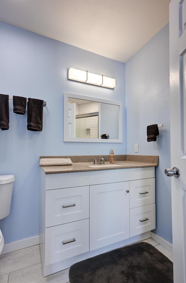 bathroom featuring tile patterned floors, vanity, and toilet