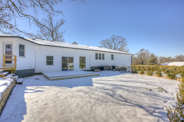 view of snow covered back of property