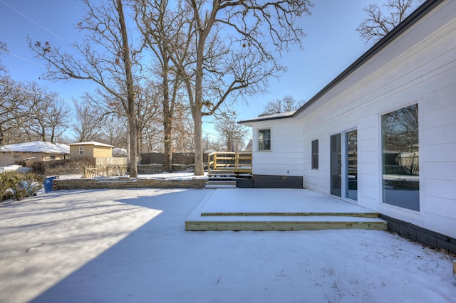 snow covered patio with a deck