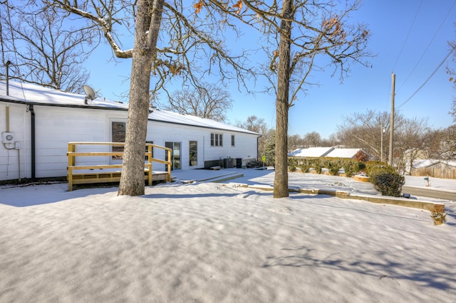 snow covered house with a wooden deck