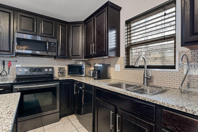 kitchen with stainless steel appliances, light tile patterned flooring, sink, and decorative backsplash