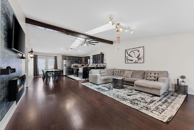 living room featuring lofted ceiling with skylight, ceiling fan, and dark hardwood / wood-style flooring