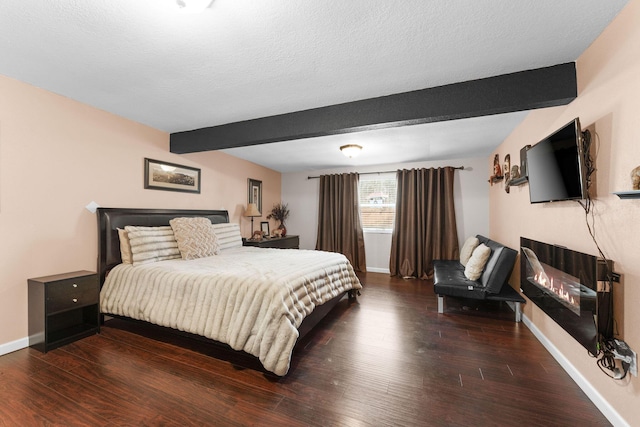 bedroom with dark hardwood / wood-style flooring, a textured ceiling, and beam ceiling