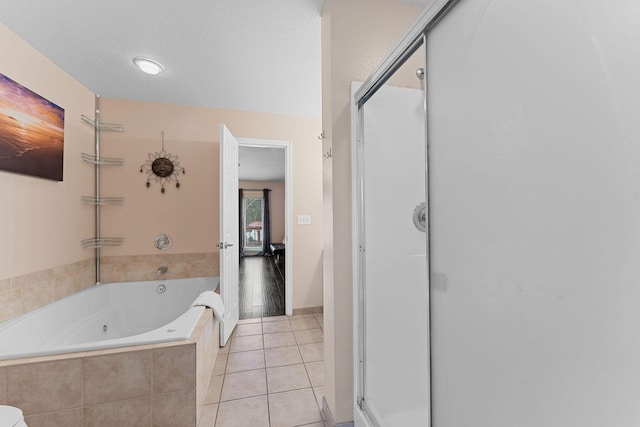 bathroom featuring tile patterned flooring, plus walk in shower, and a textured ceiling
