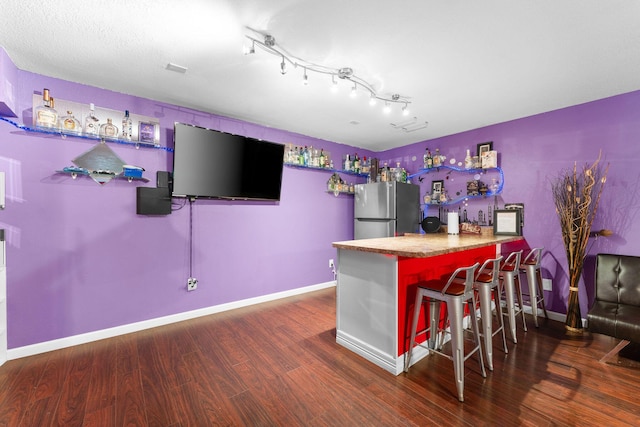 bar featuring stainless steel refrigerator and dark wood-type flooring