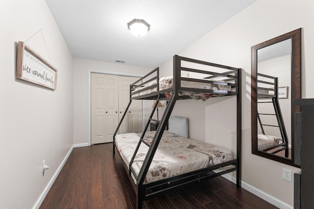 bedroom featuring dark wood-type flooring and a closet