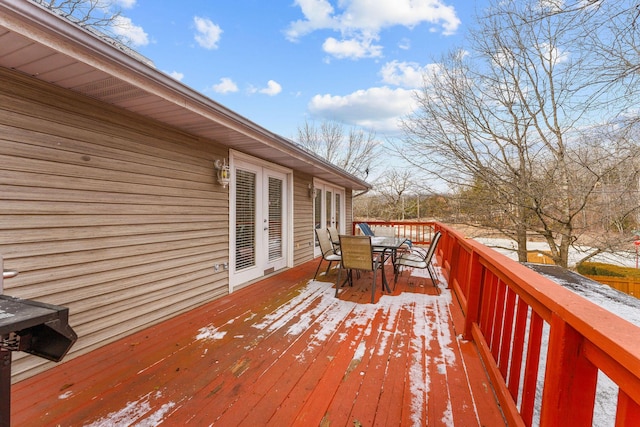 snow covered deck featuring french doors