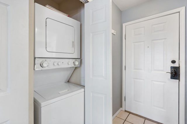 clothes washing area with stacked washer and clothes dryer and light tile patterned floors