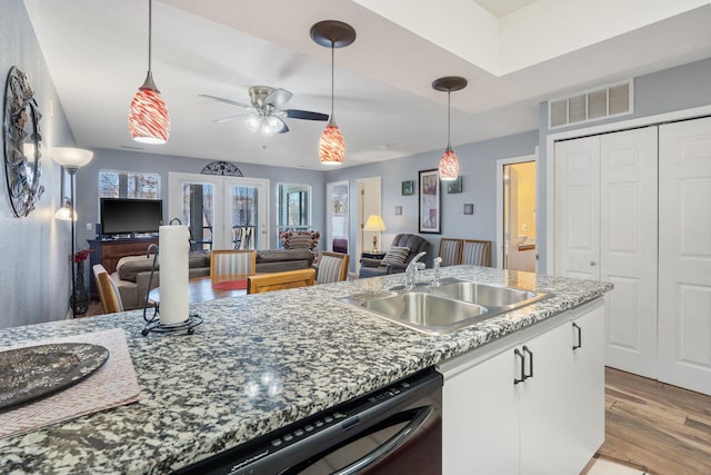 kitchen featuring pendant lighting, sink, light hardwood / wood-style flooring, white cabinetry, and french doors