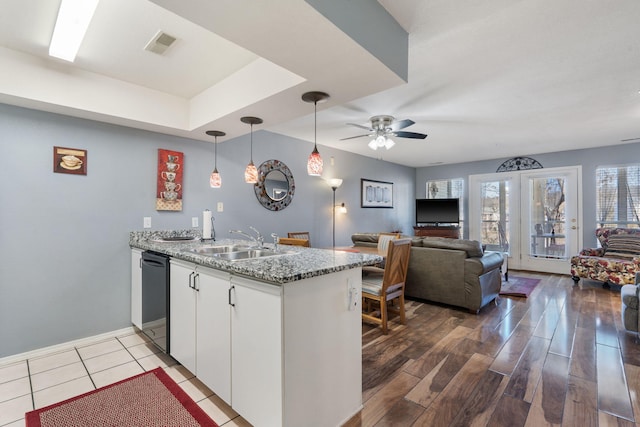 kitchen featuring dishwasher, wood-type flooring, sink, white cabinets, and kitchen peninsula