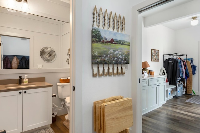 bathroom with hardwood / wood-style flooring, vanity, and toilet