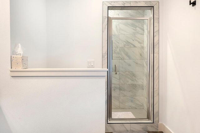 bathroom featuring a shower with door