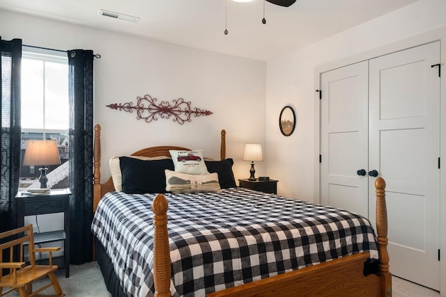 bedroom with ceiling fan, light colored carpet, and a closet