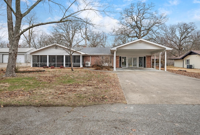 ranch-style home with a carport and a sunroom