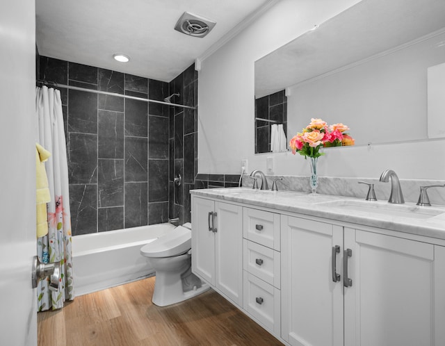 full bathroom featuring shower / tub combo with curtain, vanity, wood-type flooring, ornamental molding, and toilet