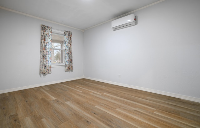 empty room featuring ornamental molding, light wood-type flooring, and a wall unit AC