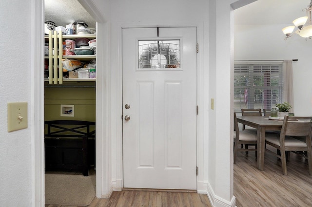 entryway featuring a chandelier and light wood-type flooring