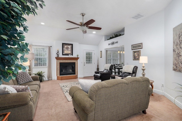 carpeted living room with a fireplace, ceiling fan, and vaulted ceiling