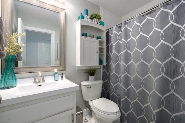 bathroom featuring vanity, toilet, and curtained shower