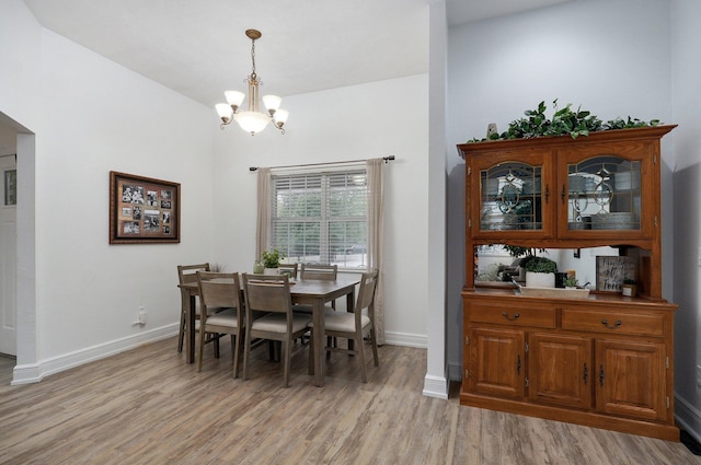 dining space featuring an inviting chandelier and light hardwood / wood-style flooring