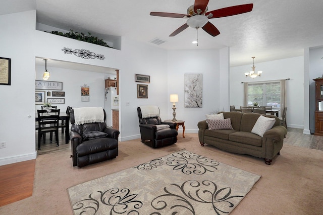 living room featuring hardwood / wood-style floors and ceiling fan with notable chandelier