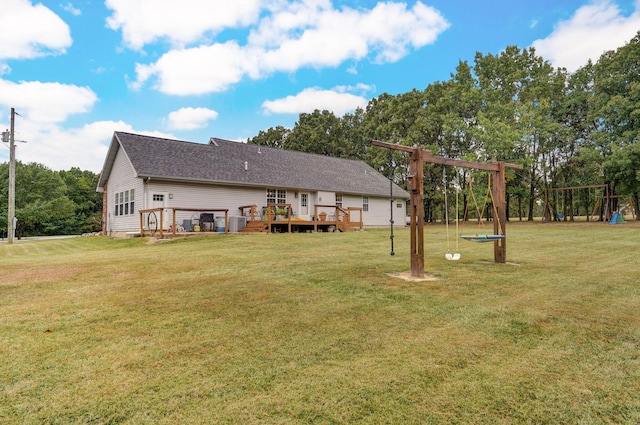 rear view of property with a playground, a deck, and a lawn