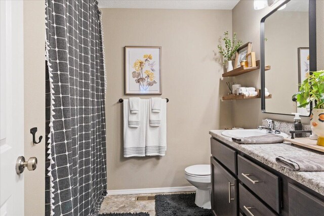 bathroom with vanity, a shower with shower curtain, visible vents, baseboards, and toilet