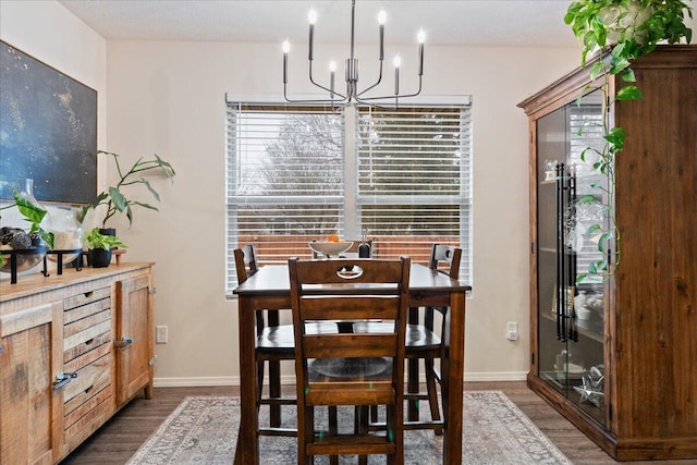 dining area featuring a notable chandelier, baseboards, and dark wood-style flooring