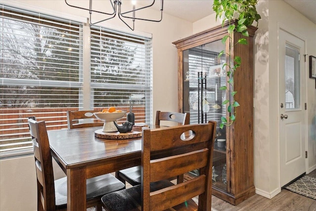 dining space with an inviting chandelier and wood finished floors