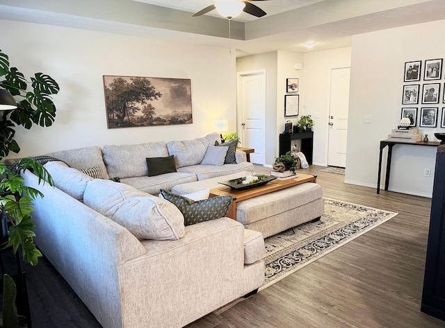 living area featuring wood finished floors, baseboards, and ceiling fan