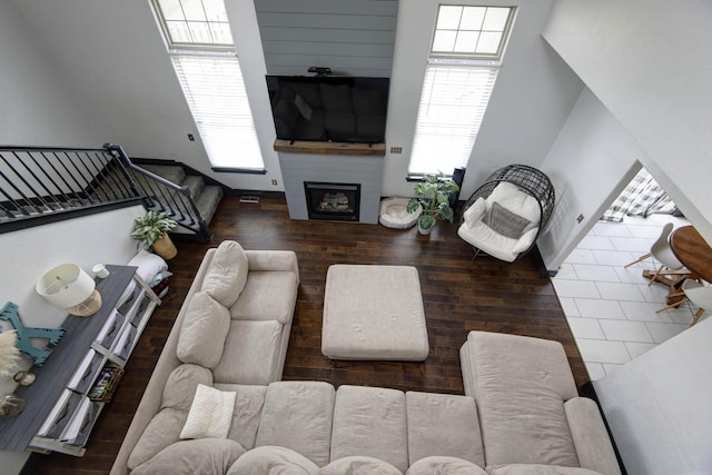 living room with a wealth of natural light, a fireplace, and dark hardwood / wood-style floors