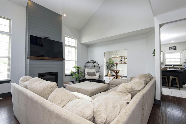 living room featuring a large fireplace, a wealth of natural light, and dark hardwood / wood-style floors