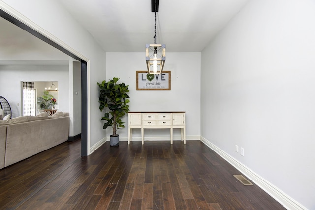 dining space featuring an inviting chandelier and dark hardwood / wood-style flooring