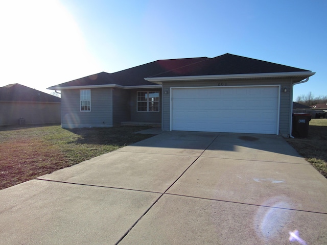 ranch-style home with driveway, an attached garage, and a front yard