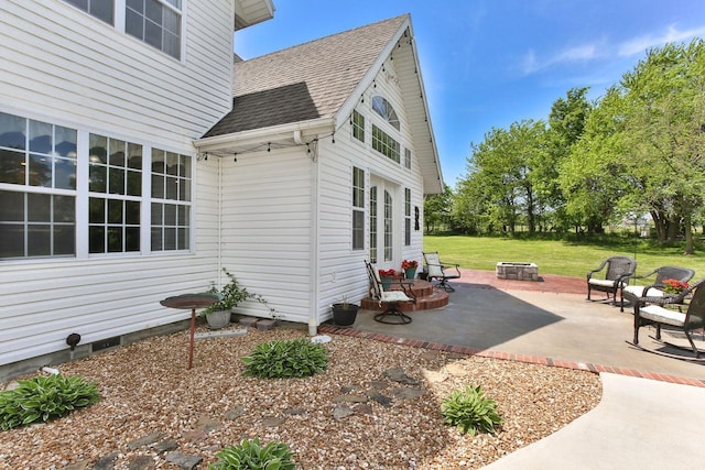 view of side of home featuring a patio area and a fire pit