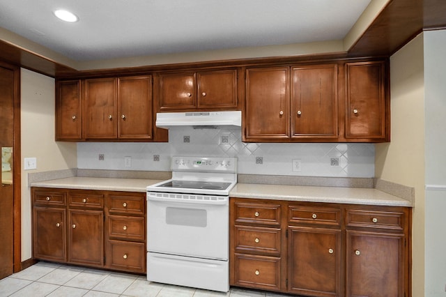 kitchen featuring white electric range oven, decorative backsplash, and light tile patterned floors